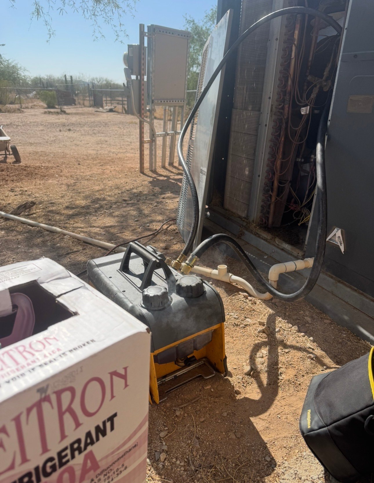Technician pulling vacuum on HVAC package unit in Tucson, AZ