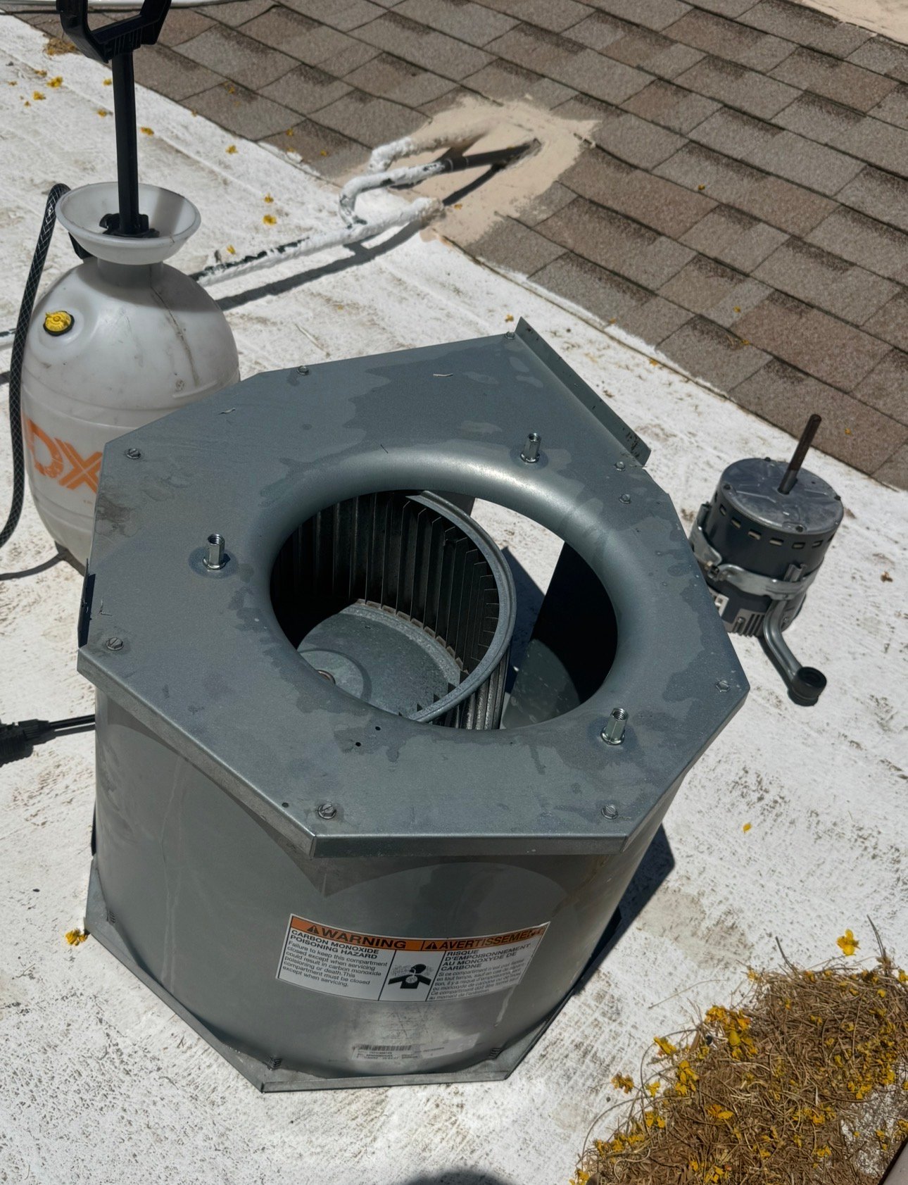 Technician cleaning blower wheel during AC tune-up service
