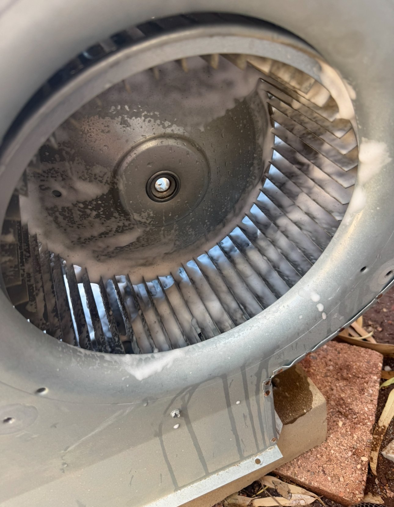 Blower wheel being cleaned with soap during AC maintenance in Marana.