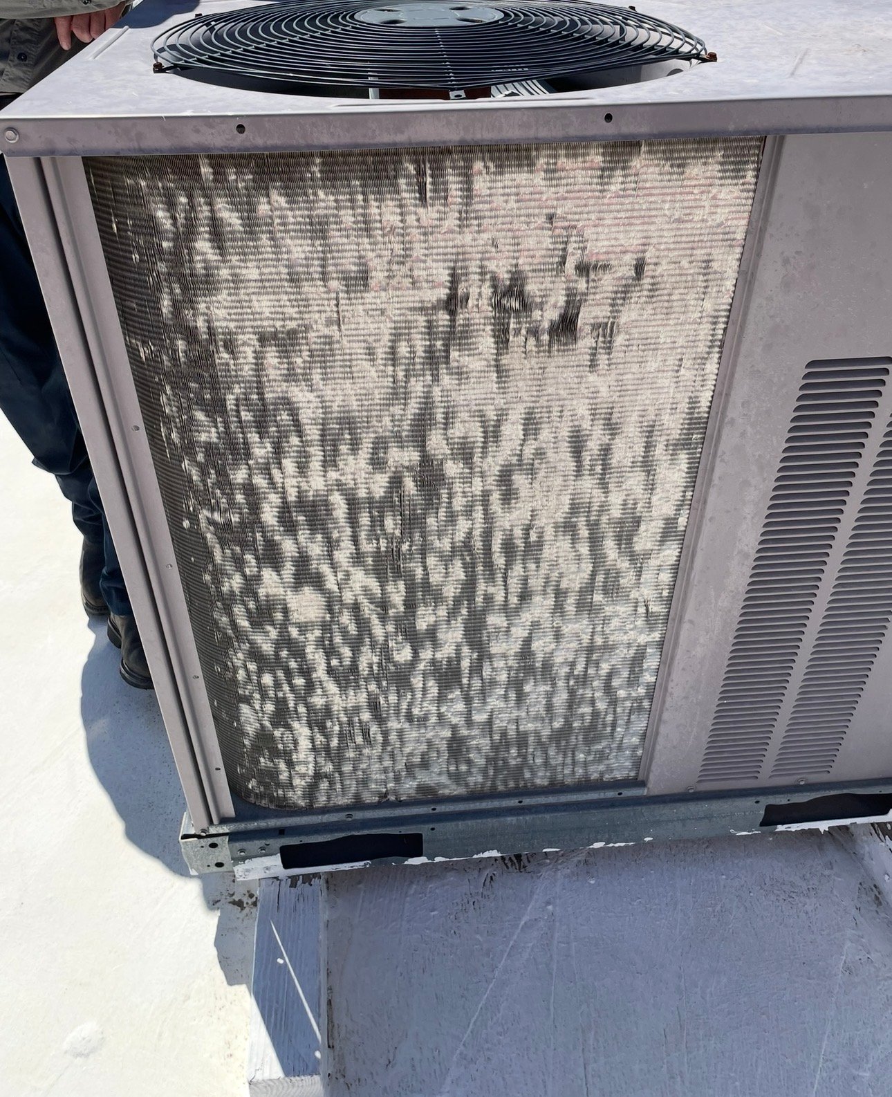 Hail-damaged condenser coil on a commercial HVAC unit