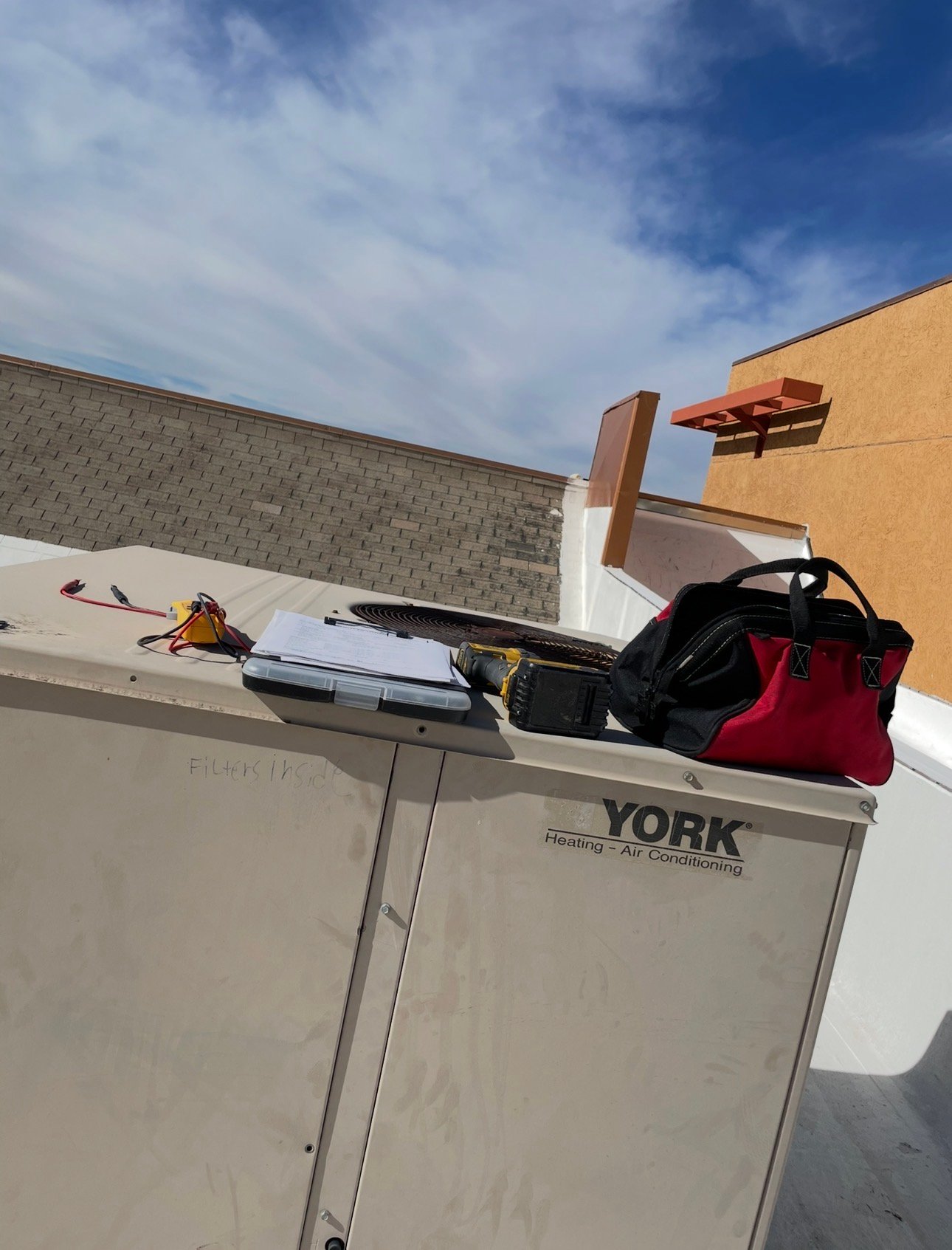 Technician’s tools set up on an old York commercial HVAC package unit