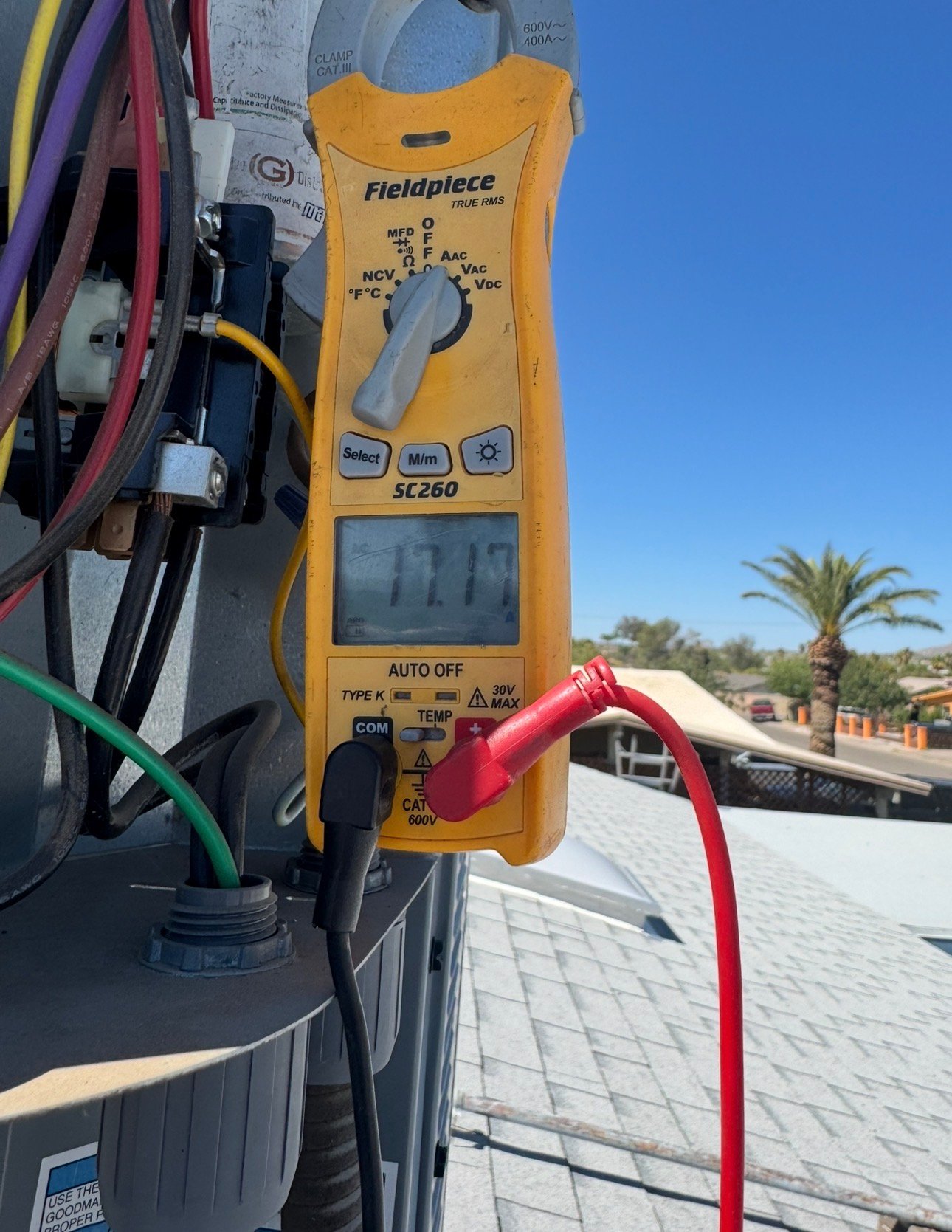 Technician measuring compressor amp draw on residential AC system in Old Spanish Trail Estates, Tucson
