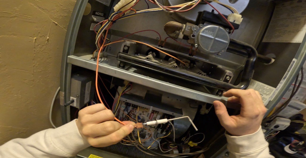 Technician repairing furnace flame sensor during furnace repair in Tucson