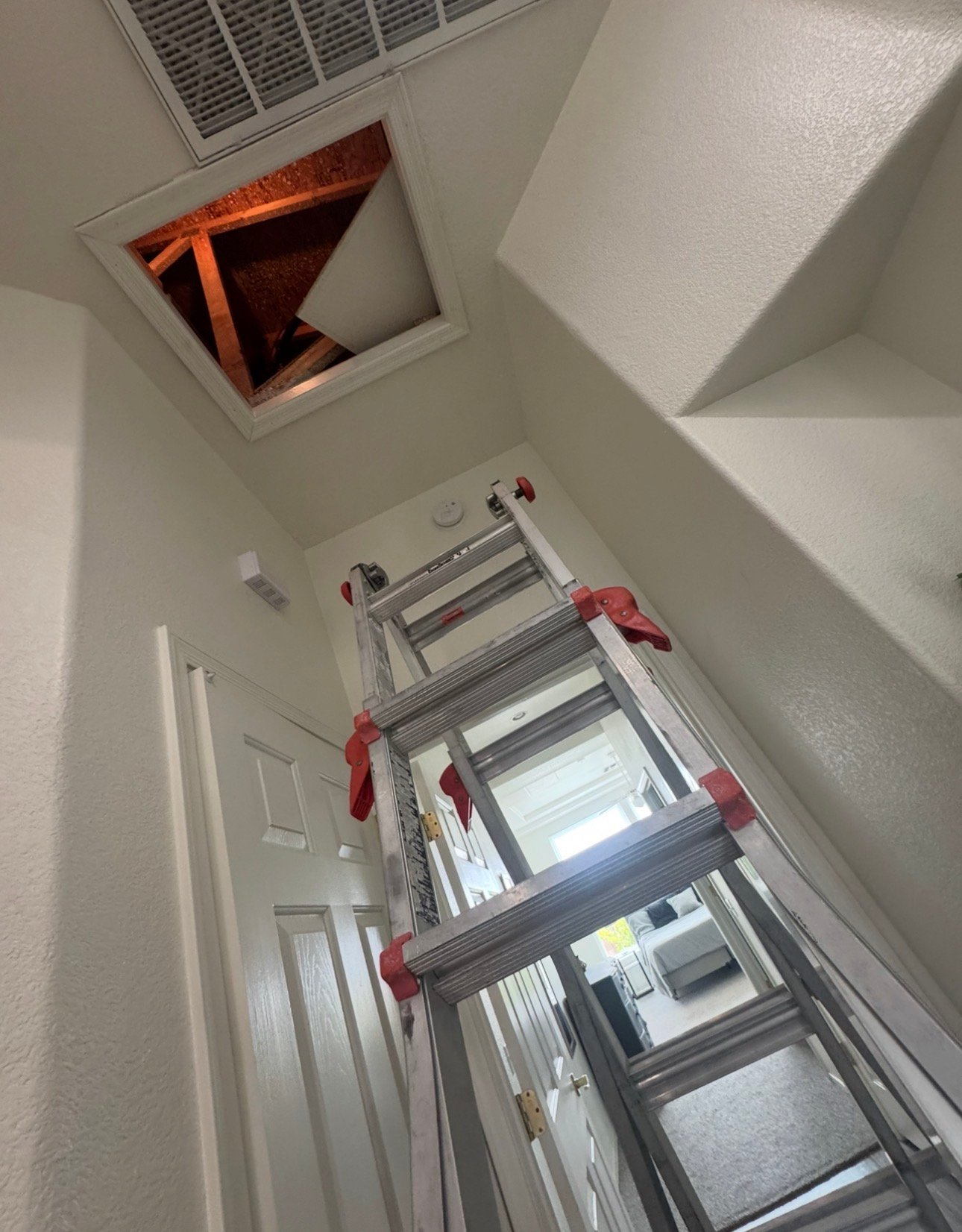 Technician using ladder to access attic HVAC system in Tucson Estates